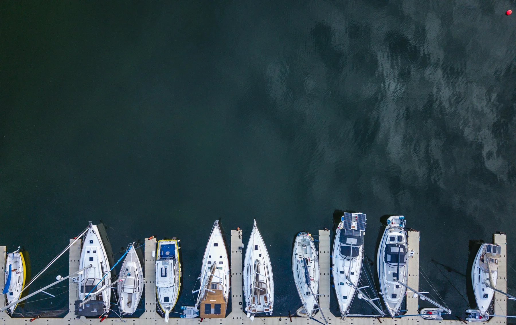 Overhead view of boats docked along the edge of open water at the club